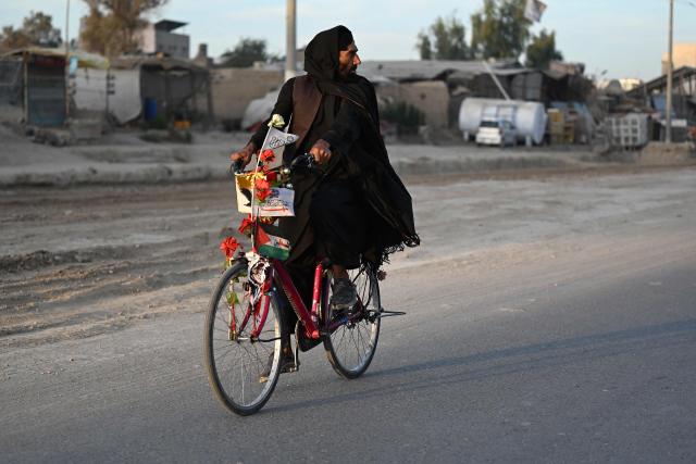 An Afghan man cycles along a road in Kandahar on October 13, 2026. (Photo by Sanaullah SEIAM / AFP)