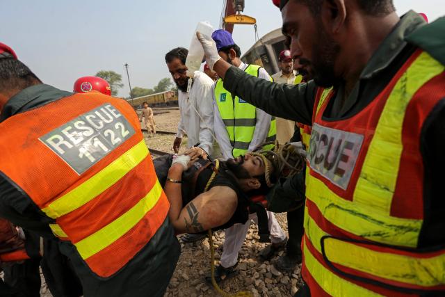 Rescue personnel carry an injured victim following the derailment of passenger train Rehman Baba Express on the outskirts of Multan on October 13, 2026. At least four people were killed and over a dozen others injured in a train derailment on October 13 near Multan in the south of Pakistan's Punjab province, emergency services and a rescue worker told AFP. (Photo by Shahid Saeed MIRZA / AFP)