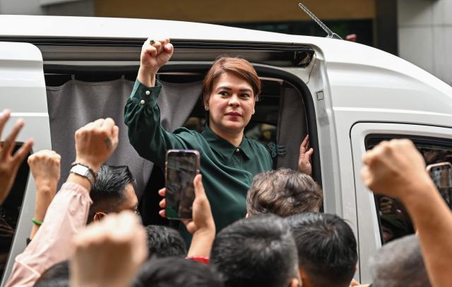 (FILES) Philippine Vice President Sara Duterte gestures as she leaves the Hall of Justice in Quezon City, Metro Manila on September 11, 2026. A Philippine impeachment court on October 13, 2026 granted prosecutors' request to drop two charges against Vice President Sara Duterte, including an alleged assassination threat, leaving accusations of unexplained wealth the sole remaining count against her. (Photo by Jam STA ROSA / AFP)