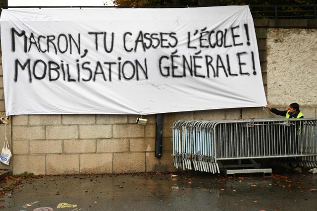 This photograph shows a banner which reads as 'Macron, You break scholl! General mobilization!' ahead of the start of a demonstration of high-school students in Nantes, western France on October 13, 2026, as part of a nationwide high school mobilisation over learning conditions. France sees nationwide demonstrations on October 13 in support of students protesting poor classroom conditions for weeks, as authorities and participants remain wary of further violence. (Photo by Sebastien Salom-Gomis / AFP)