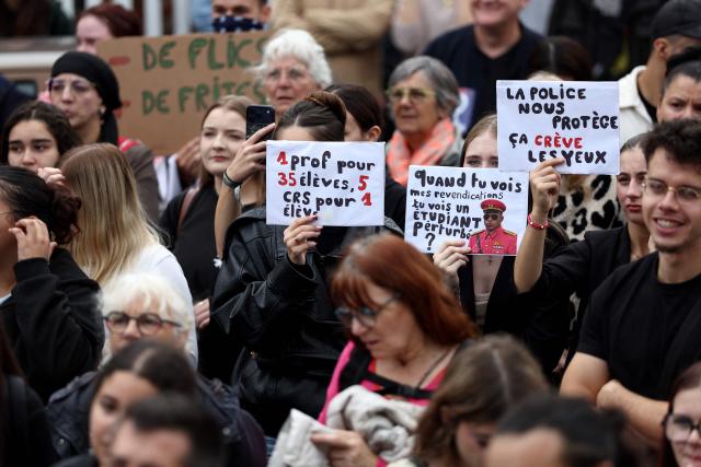 Protesters hold placards, including one bearing a portrait of French footballer Kylian Mbappe in a military uniform reading "When you see my demands, do you see a disturbed student?" during a demonstration of students in Lens, northern France on October 13, 2026, as part of a nationwide high school mobilisation. France sees nationwide demonstrations on October 13 in support of students protesting poor classroom conditions for weeks, as authorities and participants remain wary of further violence. (Photo by Sameer AL-DOUMY / AFP)