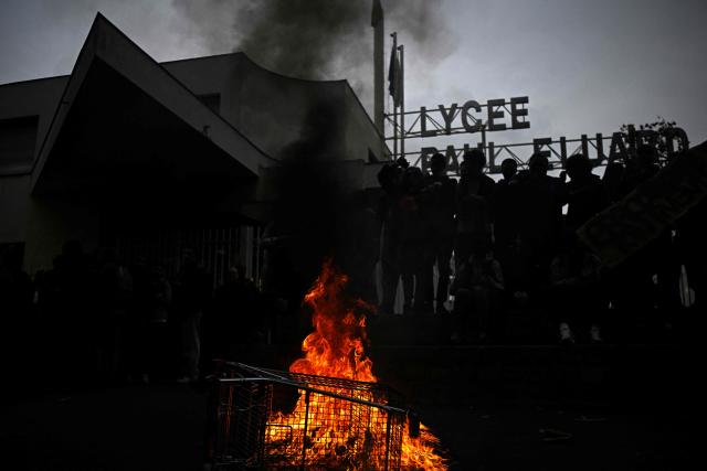 Protesters set a rubbish bin on fire during a blockade at the entrance of Lycee Paul Eluard in Saint-Denis, on the outskirts of Paris on October 13, 2026, as part of a nationwide student mobilisation. France sees nationwide demonstrations on October 13 in support of students protesting poor classroom conditions for weeks, as authorities and participants remain wary of further violence. (Photo by JULIEN DE ROSA / AFP)