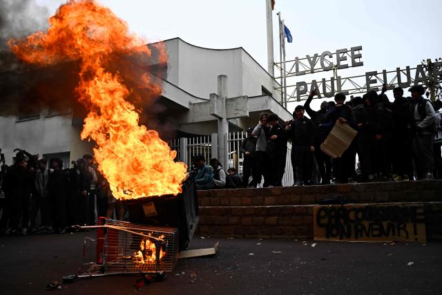 Protesters set a rubbish bin on fire during a blockade at the entrance of Lycee Paul Eluard in Saint-Denis, on the outskirts of Paris on October 13, 2026, as part of a nationwide student mobilisation. France sees nationwide demonstrations on October 13 in support of students protesting poor classroom conditions for weeks, as authorities and participants remain wary of further violence. (Photo by JULIEN DE ROSA / AFP)