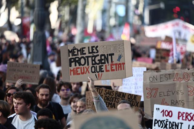 A protester holds a placard which reads as 'Even condoms protect better than the State' during a demonstration of high-school students in Marseille, southern France on October 13, 2026, as part of a nationwide high school mobilisation over learning conditions. France sees nationwide demonstrations on October 13 in support of students protesting poor classroom conditions for weeks, as authorities and participants remain wary of further violence. (Photo by Thibaud MORITZ / AFP)
