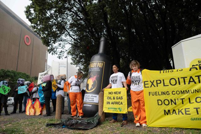 Greenpeace activists protest outside the Cape Town International Convention Centre, calling for oil and gas companies attending the African Energy Week 2026 to pay back for climate damage in Africa, in Cape Town on October 13, 2026. (Photo by RODGER BOSCH / AFP)