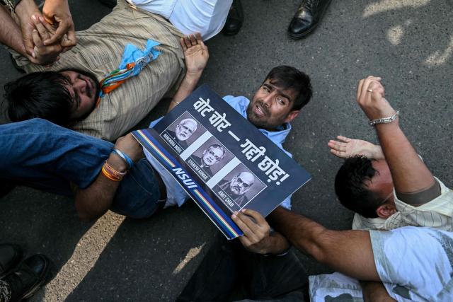 Security personnel detain student activists during a protest demanding the resignation of the nation's Chief Election Commissioner Gyanesh Kumar over alleged voter roll irregularities linked to the "special intensive revision" (SIR), in New Delhi on October 13, 2026. (Photo by Arun SANKAR / AFP)