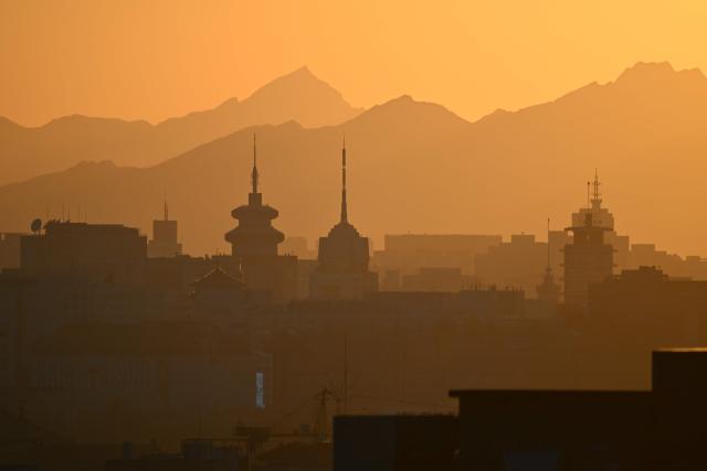 Buildings are seen on the Beijing skyline at sunset on October 13, 2026. (Photo by GREG BAKER / AFP)