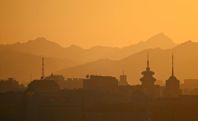 Buildings are seen on the Beijing skyline at sunset on October 13, 2026. (Photo by GREG BAKER / AFP)