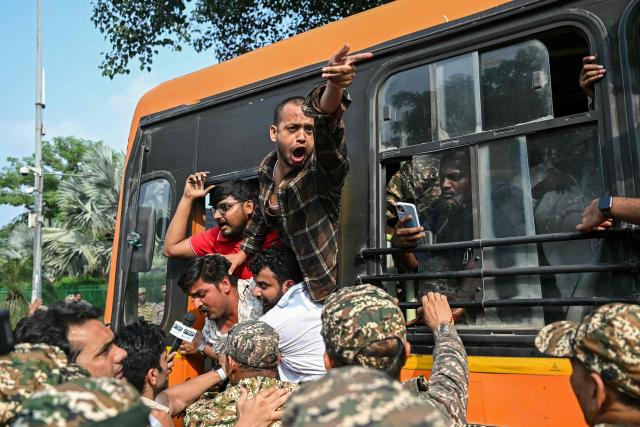 Security personnel detain student activists in a bus during a protest demanding the resignation of the nation's Chief Election Commissioner Gyanesh Kumar over alleged voter roll irregularities linked to the "special intensive revision" (SIR), in New Delhi on October 13, 2026. (Photo by Arun SANKAR / AFP)