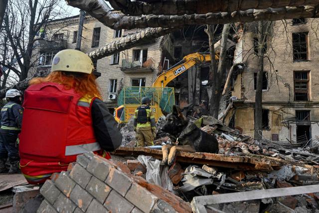 Ukrainian rescuers work to clear rubble as they operate at the site of an apartment building in Kharkiv on October 13, 2026, after it was heavily damaged in a Russian drone strike overnight, amid the Russian invasion of Ukraine. (Photo by SERGEY BOBOK / AFP)