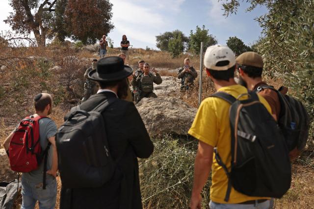 Israeli security forces and armed settlers evacuate Palestinians and Israeli activists from the area of olive tree plantation in Idna village near the occupied West Bank town of Hebron, on October 13, 2026. The olive harvest starts in the West Bank in October and makes up a large component of the agricultural economy and cultural life for most Palestinians. Extremist Israeli settlers have been seizing olive groves owned by Palestinians, who see the trees as a cultural symbol. The olive harvest is a major component of the West Banks agricultural economy, rural livelihoods and cultural life. (Photo by HAZEM BADER / AFP)