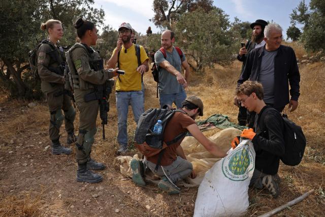 Israeli security forces and settlers evacuate Palestinians and Israeli activists from the area of olive tree plantation in Idna village near the occupied West Bank town of Hebron, on October 13, 2026. The olive harvest starts in the West Bank in October and makes up a large component of the agricultural economy and cultural life for most Palestinians. Extremist Israeli settlers have been seizing olive groves owned by Palestinians, who see the trees as a cultural symbol. The olive harvest is a major component of the West Banks agricultural economy, rural livelihoods and cultural life. (Photo by HAZEM BADER / AFP)