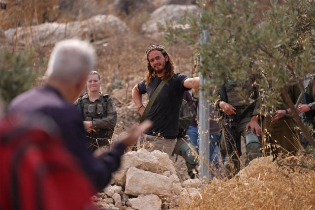 Israeli security forces and armed settlers evacuate Palestinians and Israeli activists from the area of olive tree plantation in Idna village near the occupied West Bank town of Hebron, on October 13, 2026. The olive harvest starts in the West Bank in October and makes up a large component of the agricultural economy and cultural life for most Palestinians. Extremist Israeli settlers have been seizing olive groves owned by Palestinians, who see the trees as a cultural symbol. The olive harvest is a major component of the West Banks agricultural economy, rural livelihoods and cultural life. (Photo by HAZEM BADER / AFP)