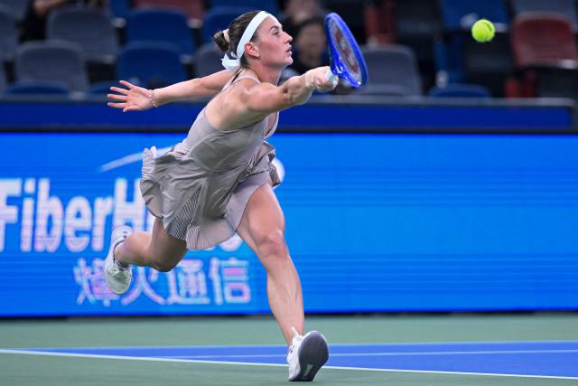 Ukraine's Marta Kostyuk hits a return to Greece's Maria Sakkari during their women’s singles match at the Wuhan Open tennis tournament in Wuhan, China's Hubei province on October 13, 2026. (Photo by WANG Zhao / AFP)
