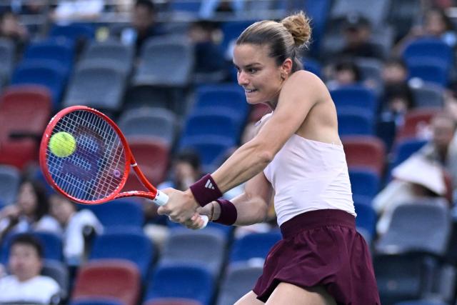 Greece's Maria Sakkari hits a return to Ukraine's Marta Kostyuk during their women’s singles match at the Wuhan Open tennis tournament in Wuhan, China's Hubei province on October 13, 2026. (Photo by WANG Zhao / AFP)