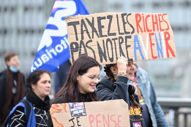 A protester holds a placard reading "Tax rich people, not our future" during a demonstration of high-school students in Nancy, northeastern France on October 13, 2026, as part of a nationwide high school mobilisation. France sees nationwide demonstrations on October 13 in support of students protesting poor classroom conditions for weeks, as authorities and participants remain wary of further violence. (Photo by Jean-Christophe VERHAEGEN / AFP)