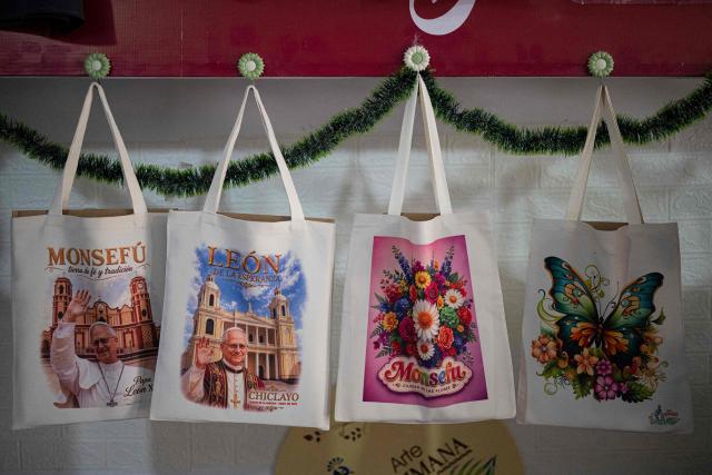 This image shows tote bags for sale regarding the upcoming visit of Pope Leo XIV at a store in the Lambayeque department, near Chiclayo, northern Peru, on October 12, 2026. Pope Leo XIV was admitted to hospital on October 13, 2026, for surgery to remove a lump from his lung, the Vatican said. He is expected to recover from the operation in time for the 11-day official trip to Latin America, that will see him visit Uruguay, Argentina and Peru. (Photo by Ernesto BENAVIDES / AFP)