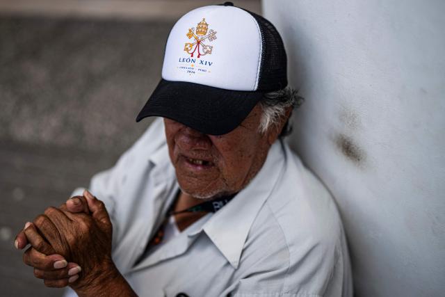 A man wears a cap made for the upcoming visit of Pope Leo XIV in the Lambayeque department, near Chiclayo, northern Peru on October 11, 2026. Pope Leo XIV was admitted to hospital on October 13, 2026, for surgery to remove a lump from his lung, the Vatican said. He is expected to recover from the operation in time for the 11-day official trip to Latin America, that will see him visit Uruguay, Argentina and Peru. (Photo by Ernesto BENAVIDES / AFP)
