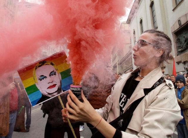 (FILES) A protester holds a sign depicting then Hungary's Prime Minister Viktor Orban during a protest in Budapest on March 25, 2025 against the government's efforts to restrict the freedom of assembly and expand its surveillance powers. Hungarian lawmakers on October 13, 2026 voted to remove anti-LGBTQ provisions in a 2021 "child protection" law adopted under nationalist ex-leader Viktor Orban. Parliament passed a bill with 139 votes in favour and 51 votes against, marking the first significant reversal of Orban's curbs targeting the LGBTQ community since pro-EU Prime Minister Peter Magyar took power in May 2026. (Photo by Peter Kohalmi / AFP)