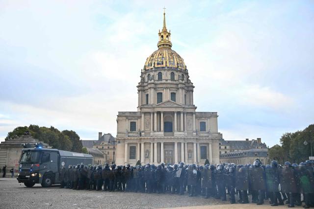 Police officers hold their position during a demonstration of high-school students near Cathedral of Saint-Louis-des-Invalides in Paris, on October 13, 2026, as part of a nationwide high school mobilisation. France sees nationwide demonstrations on October 13 in support of students protesting poor classroom conditions for weeks, as authorities and participants remain wary of further violence. (Photo by LOU BENOIST / AFP)