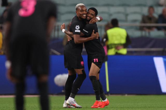 Sabah FK's Jamaican midfielder #11 Kaheem Parris celebrates with Sabah FK's Rwandan forward #20 Joy-Lance Mickels after scoring the team's first goal during the UEFA Champions League match between Sabah and Slavia Praha at the Baku Olympic Stadium in Baku on October 13, 2026. (Photo by Giorgi ARJEVANIDZE / AFP)