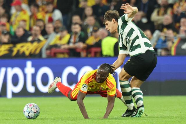 Lens' midfielder #21 Amadou Haidara (L) falls, by Sporting's defender #72 Eduardo Quaresma during the UEFA Champions League, league phase matchday 2, football match between RC Lens and Sporting CP at the Stade Bollaert-Delelis in Lens, northern France, on October 13, 2026. (Photo by Francois LO PRESTI / AFP)