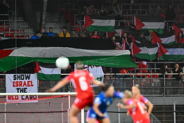 Pro-Palestinian demonstrators stage a protest in the stands during the Women’s FIFA World Cup 2027 qualifyers play-off football match between Switzerland and Israel at Stade de Tourbillon in Sion, Switzerland, on October 13, 2026. (Photo by Fabrice COFFRINI / AFP)