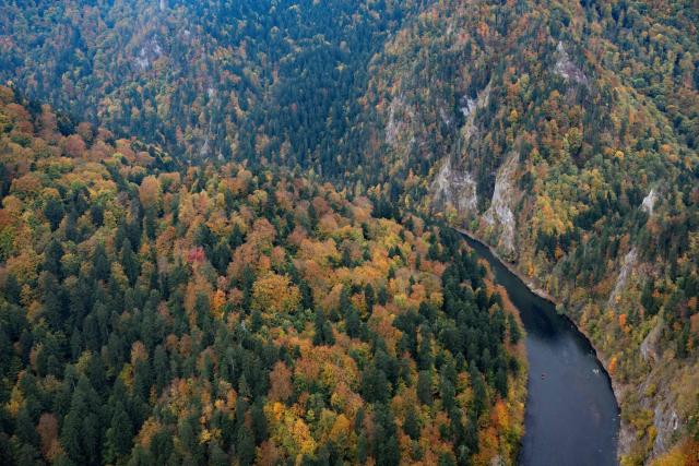 Tourists take a traditional rafting trip on the Dunajec River aboard a wooden raft guided by local raftsmen near the village of Sromowce Nizne, Lesser Poland Voivodeship on October 13, 2026. (Photo by Sergei GAPON / AFP)