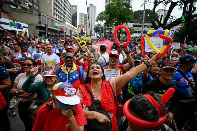 Supporters of Venezuela's government take part in a march in support of the dialogue process between a sector of the opposition and the government, and to demand the lifting of sanctions against Venezuela, in Caracas on October 13, 2026. (Photo by Federico PARRA / AFP)