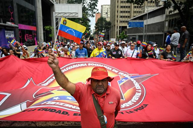 Supporters of Venezuela's government take part in a march in support of the dialogue process between a sector of the opposition and the government, and to demand the lifting of sanctions against Venezuela, in Caracas on October 13, 2026. (Photo by Federico PARRA / AFP)