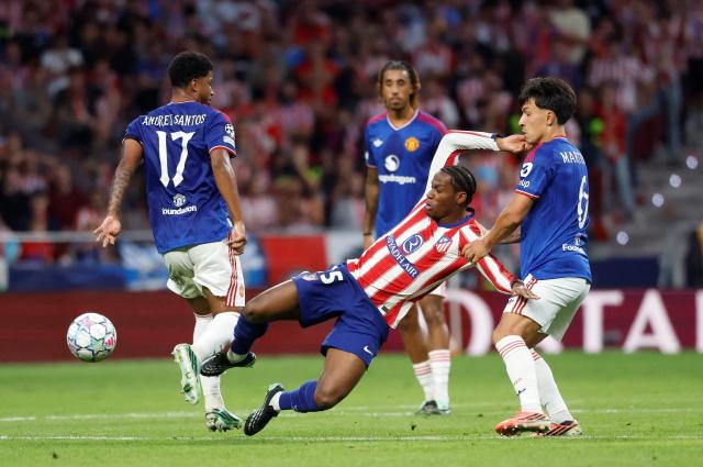 Atletico Madrid's Canadian forward #15 Jonathan David fights for the ball with Manchester United's Argentinian defender #06 Lisandro Martinez during the UEFA Champions League, league phase, matchday 2,  football match between Club Atletico de Madrid and Manchester United at the Metropolitano stadium in Madrid on October 13, 2026. (Photo by Oscar DEL POZO / AFP)