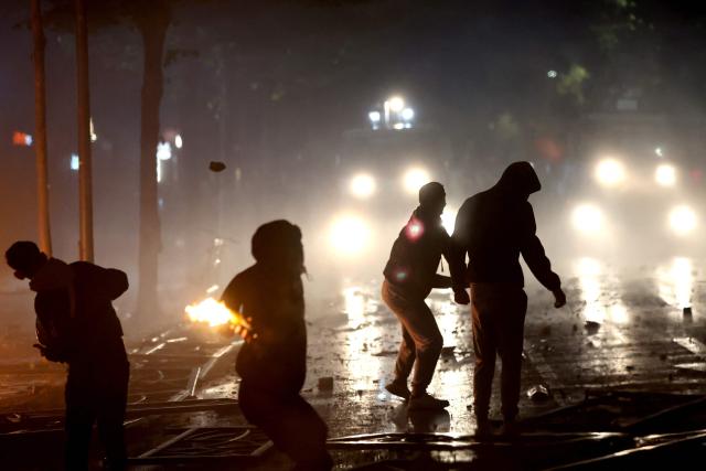 Protesters throw projectiles during clashes with riot police in Skanderbeg square during a protest in Tirana on October 13, 2026, as hundreds rallied to demand the resignation of Albanian Prime Minister Edi Rama and better education. Police used tear gas and water cannons as protesters threw stones, smashed windows at the education ministry, tore down a fence and set rubbish bins on fire, with six police officers and a female journalist injured, according to police. (Photo by Adnan Beci / AFP)