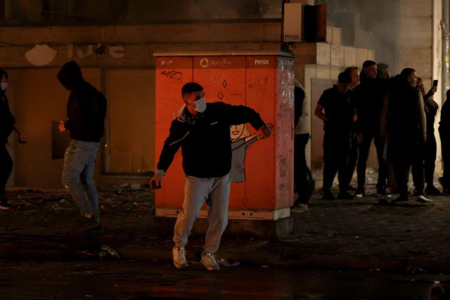 Protesters throw projectiles during clashes with riot police in Skanderbeg square during a protest in Tirana on October 13, 2026, as hundreds rallied to demand the resignation of Albanian Prime Minister Edi Rama and better education. Police used tear gas and water cannons as protesters threw stones, smashed windows at the education ministry, tore down a fence and set rubbish bins on fire, with six police officers and a female journalist injured, according to police. (Photo by Adnan Beci / AFP)