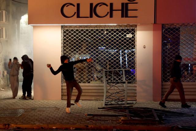 A protester throws a projectile during clashes with riot police in Skanderbeg square during a protest in Tirana on October 13, 2026, as hundreds rallied to demand the resignation of Albanian Prime Minister Edi Rama and better education. Police used tear gas and water cannons as protesters threw stones, smashed windows at the education ministry, tore down a fence and set rubbish bins on fire, with six police officers and a female journalist injured, according to police. (Photo by Adnan Beci / AFP)
