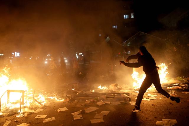 A protester throws a projectile during clashes with riot police in Skanderbeg square during a protest in Tirana on October 13, 2026, as hundreds rallied to demand the resignation of Albanian Prime Minister Edi Rama and better education. Police used tear gas and water cannons as protesters threw stones, smashed windows at the education ministry, tore down a fence and set rubbish bins on fire, with six police officers and a female journalist injured, according to police. (Photo by Adnan Beci / AFP)