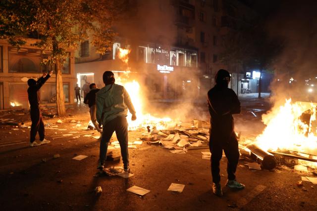 Protesters throw projectiles during clashes with riot police in Skanderbeg square during a protest in Tirana on October 13, 2026, as hundreds rallied to demand the resignation of Albanian Prime Minister Edi Rama and better education. Police used tear gas and water cannons as protesters threw stones, smashed windows at the education ministry, tore down a fence and set rubbish bins on fire, with six police officers and a female journalist injured, according to police. (Photo by Adnan Beci / AFP)