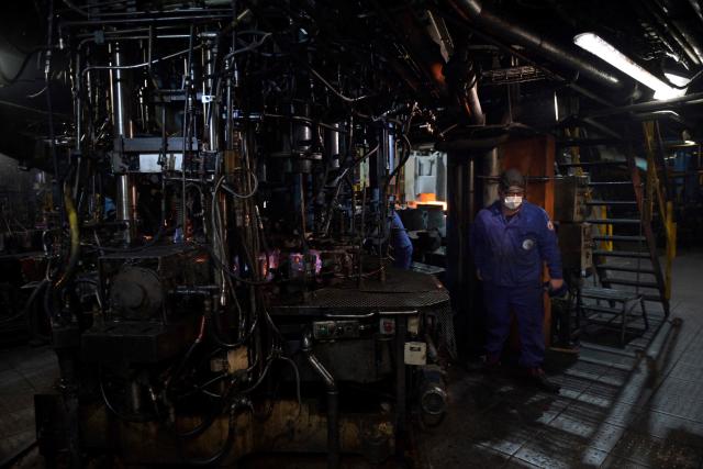 (FILES) A worker checks glasses next to the oven on the production line at a factory of French manufacturer of glassware Duralex in La Chapelle-Saint-Mesmin near Orleans, centre France, on July 1, 2021, during a visit of the French Junior Minister of Small and Medium Entreprises. (Photo by GUILLAUME SOUVANT / AFP)