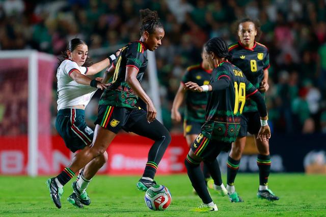 Mexico's forward #7 Alice Soto (L) fights for the ball with Jamaica’s midfielder #20 Atlanta Primus and Jamaica’s defender #19 Kameron Simmonds during the women's international friendly football match between Mexico and Jamaica at La Corregidora Stadium in Santiago de Queretaro, Queretaro State, Mexico on October 13, 2026. (Photo by Cesar Gomez / AFP)