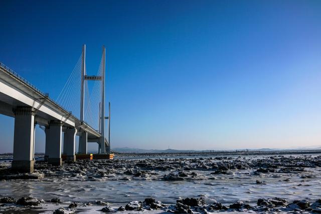 (FILES) In this photo taken on January 11, 2018, the New Yalu River vehicle bridge is seen over the Yalu river between the North Korean town of Sinuiju and Dandong in China's northeast Liaoning province. A new bridge linking China and North Korea will open this week, Chinese state media reported on October 14, 2026, twelve years after its construction, in another sign of deepening economic relations between the Asian giant and its poor neighbour. (Photo by Chandan KHANNA / AFP)