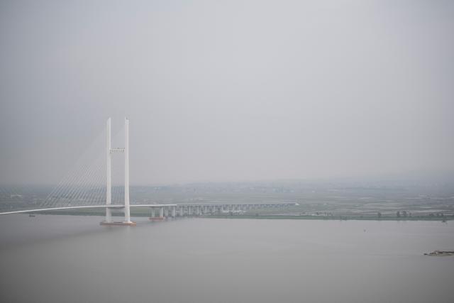 (FILES) This picture taken on May 30, 2018 shows a general view of the New Yalu River vehicle bridge leading to the North Korean city of Sinuiju seen from the border city of Dandong, in China's northeast Liaoning province. A new bridge linking China and North Korea will open this week, Chinese state media reported on October 14, 2026, twelve years after its construction, in another sign of deepening economic relations between the Asian giant and its poor neighbour. (Photo by FRED DUFOUR / AFP)