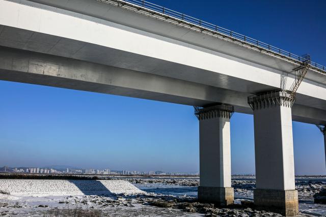 (FILES) In this photo taken on January 11, 2018, the New Yalu River vehicle bridge is seen over the Yalu river between the North Korean town of Sinuiju and Dandong in China's northeast Liaoning province. A new bridge linking China and North Korea will open this week, Chinese state media reported on October 14, 2026, twelve years after its construction, in another sign of deepening economic relations between the Asian giant and its poor neighbour. (Photo by Chandan KHANNA / AFP)