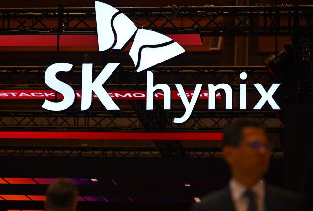 A man walks past the logo of SK hynix during a semiconductor exhibition at the COEX convention and exhibition centre in Seoul on October 14, 2026. (Photo by Jung Yeon-je / AFP)