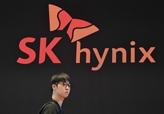 A man walks past the logo of SK hynix during a semiconductor exhibition at the COEX convention and exhibition centre in Seoul on October 14, 2026. (Photo by Jung Yeon-je / AFP)