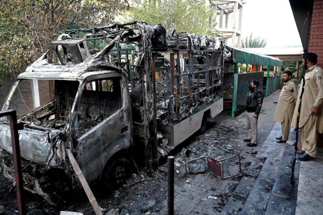Security personnel inspect burnt vehicles at the National Database and Registration Authority (NADRA) office following clashes, in Bara on the outskirts of Peshawar on October 14, 2026. (Photo by Abdul MAJEED / AFP)