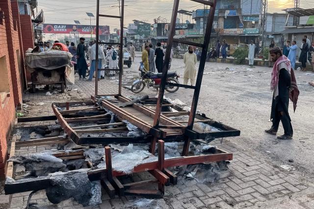 A man looks at debris on a street near the National Database and Registration Authority (NADRA) office following clashes, in Bara of Pakistan's Khyber Pakhtunkhwa province on October 14, 2026. Police opened fire at a protest in northwest Pakistan on October 13, leaving several people injured, as authorities cracked down on supporters of jailed former prime minister Imran Khan, a police official and a member of his party said. (Photo by Abdul MAJEED / AFP)