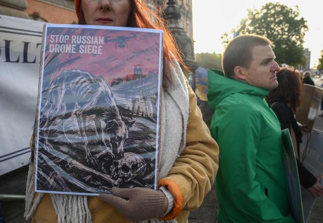 A protester holds a sign reading "Stop Russian drone siege" ahead the beginning of the trial against Ukrainian national Serhii K, a former army officer accused of the Nord Stream gas pipeline bombing around four years ago, at the Higher Regional Court in Hamburg, northern Germany on October 14, 2026. According to the indictment filed by the Federal Public Prosecutors Office, Serhii K, who was arrested last year while on vacation in Italy, is alleged to have planned the act together with other members of the Ukrainian military. In addition, the defendant is said to have led the team that blew up the natural gas pipelines under the Baltic Sea at the end of September 2022. The pipelines were used to transport Russian natural gas to Germany. According to the indictment, the attack was carried out on behalf of Ukrainian state authorities; the background was the Russian war of aggression against Ukraine, which began in early 2022. The Ukrainian government denies any official involvement. (Photo by Gregor Fischer / AFP)
