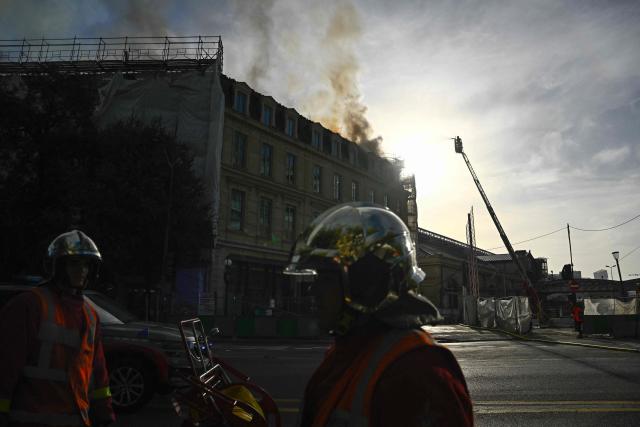Firefighters work to extinguish a fire burning on the roof of the Gare d'Austerlitz railway station in Paris on October 14, 2026. (Photo by JULIEN DE ROSA / AFP)
