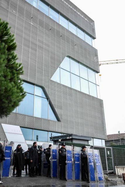 Turkish anti-riot police officers stand at the bottom of the building during a police raid at the headquarters of pro-opposition Halk TV in Istanbul, on October 14, 2026. The head of Turkey's pro-opposition Halk TV lashed out after police raided the channel's headquarters, halting live broadcasts and arresting 11 in a move against the country's most watched news channel. (Photo by BERK OZKAN / AFP)