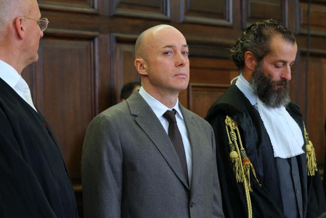 Former Ukrainian military officer Sergiy K (C, also Serhii K) is seen between his lawyers prior to the start of the trial over the Nord Stream gas pipeline bombing around four years ago, in Hamburg, northern Germany on October 14, 2026. According to the indictment filed by the Federal Public Prosecutors Office, Serhii K, who was arrested in 2025 while on vacation in Italy, is alleged to have planned the act together with other members of the Ukrainian military. In addition, the defendant is said to have led the team that blew up the natural gas pipelines under the Baltic Sea at the end of September 2022. The pipelines were used to transport Russian natural gas to Germany. According to the indictment, the attack was carried out on behalf of Ukrainian state authorities; the background was the Russian war of aggression against Ukraine, which began in early 2022. The Ukrainian government denies any official involvement. (Photo by Markus Scholz / POOL / AFP)