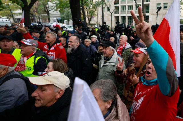 Anti-government demonstrators protest in front of the Constitutional Court, Poland's highest court, in Warsaw on October 14, 2026. Hundreds of right-wing demonstrators clashed with police in front of Poland's highest court on October 14, attempting to block its judges from entering the building and defending its overhaul by the previous government. (Photo by Wojtek RADWANSKI / AFP)